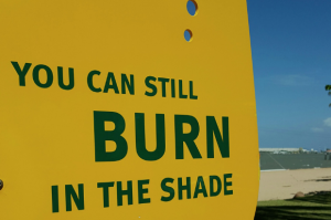 A sign containing a sun safety warning. It reads: You can still burn in the shade.