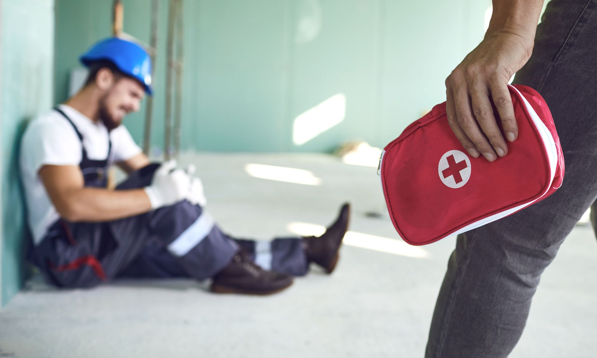 A first aid trained colleague goes to aid an injured worker